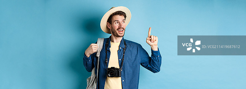 在夏季旅行中向上看并指点的英俊游客图片素材