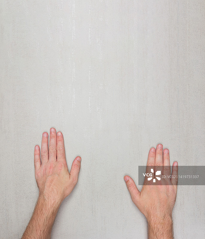 在美国，靠墙男人的手的局部照片图片素材