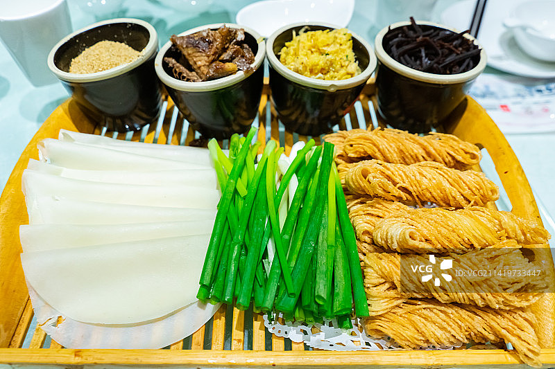 中国餐饮行业饮食产业，传统经典中国食品，美食拍摄主题，一盘子面饼卷馓子和大葱特写，室内无人图像图片素材