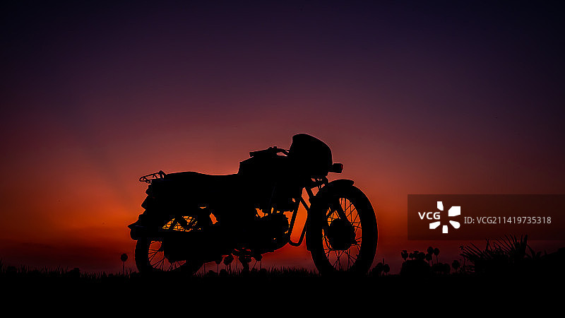 萨蒂亚曼加拉姆，泰米尔纳德邦，印度：日落时骑摩托车的骑行者剪影图片素材