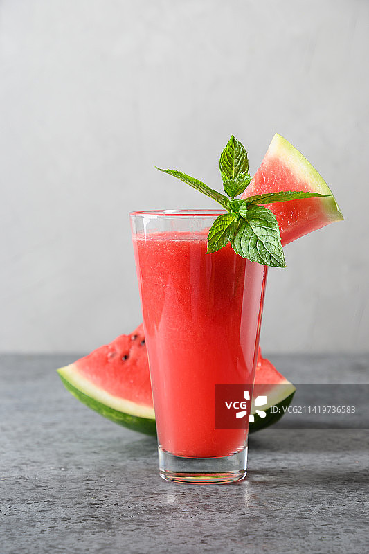 灰色背景上的西瓜鸡尾酒杯，薄荷装饰图片素材