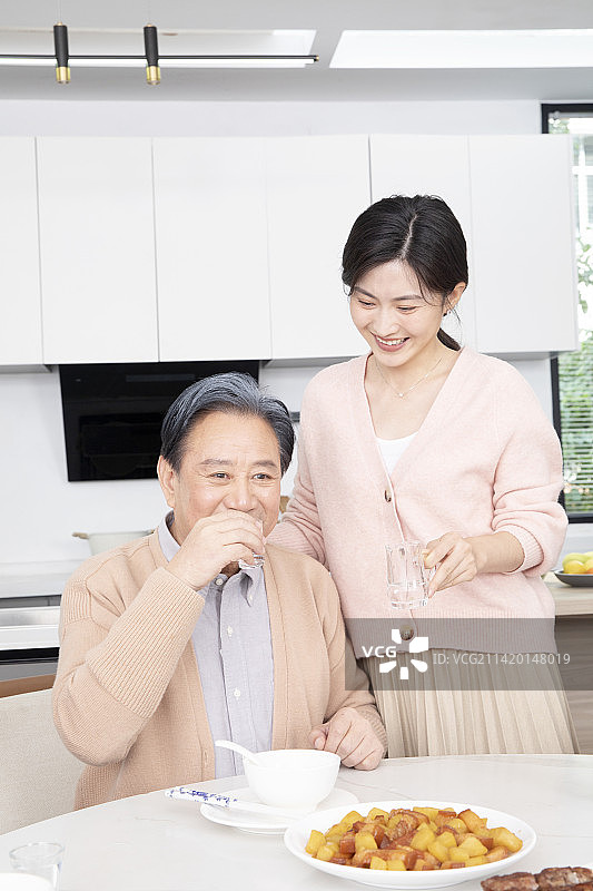 给父亲敬酒的年轻女人图片素材