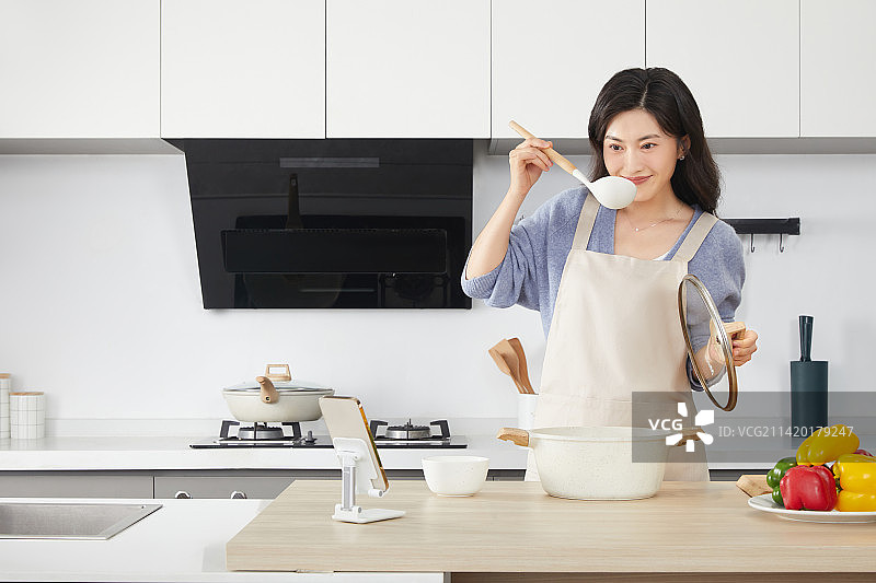 在厨房使用汤锅的年轻女人图片素材