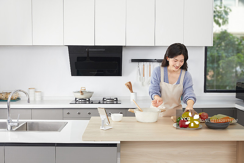 在厨房使用调味食材的年轻女人图片素材