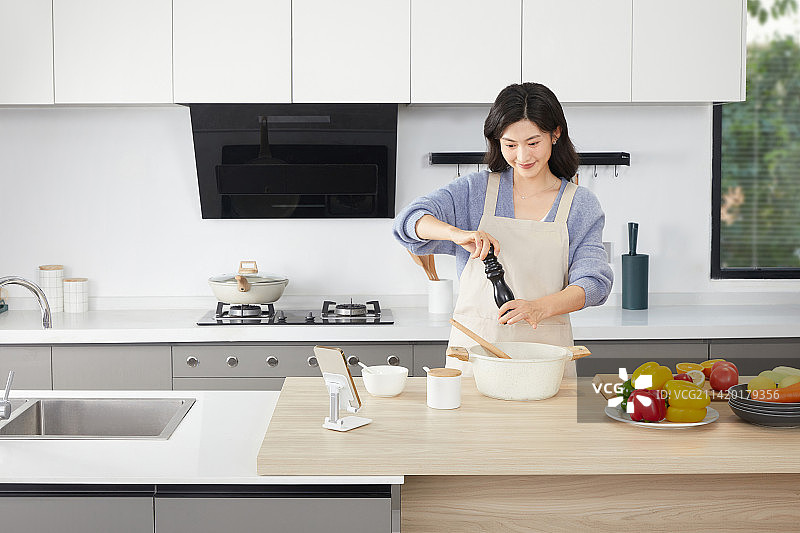 在厨房使用调味食材的年轻女人图片素材