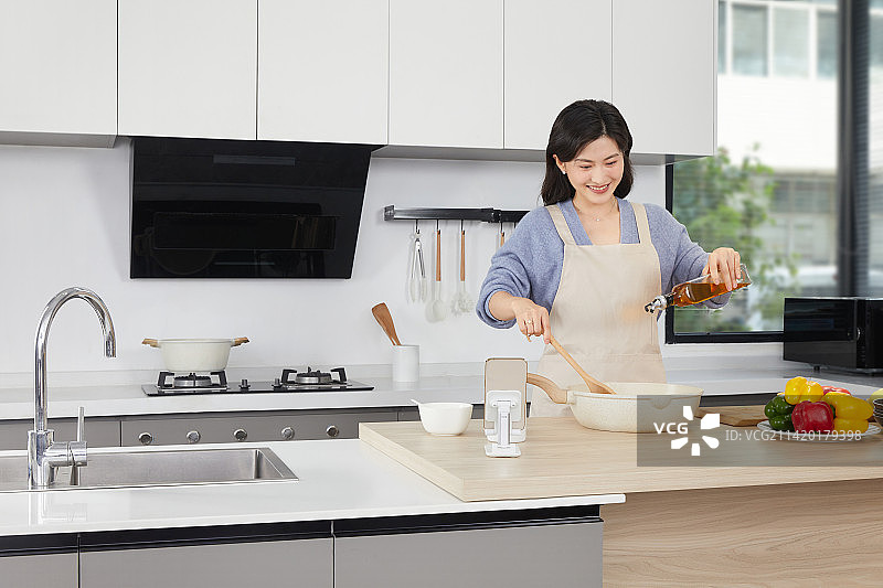 在厨房使用调味食材的年轻女人图片素材