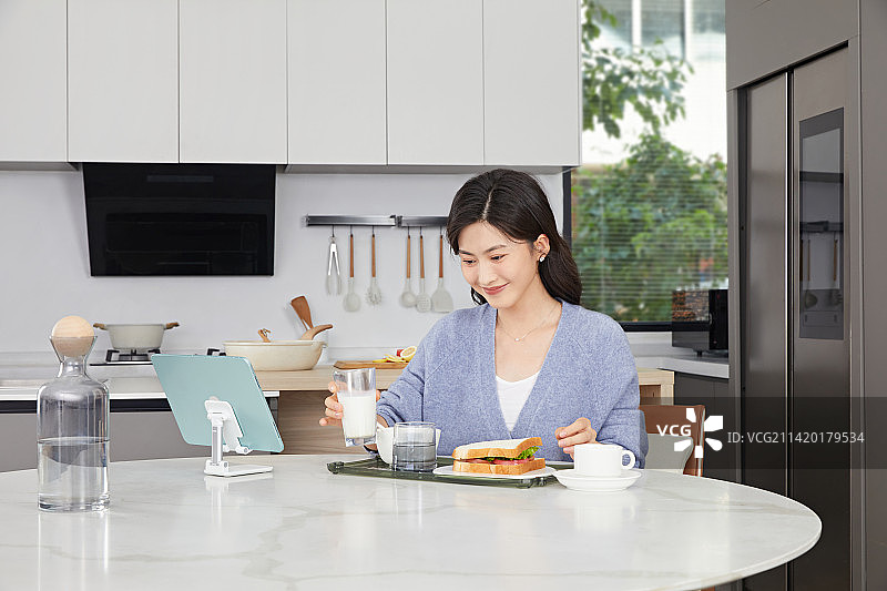 居家吃早餐的年轻女性图片素材