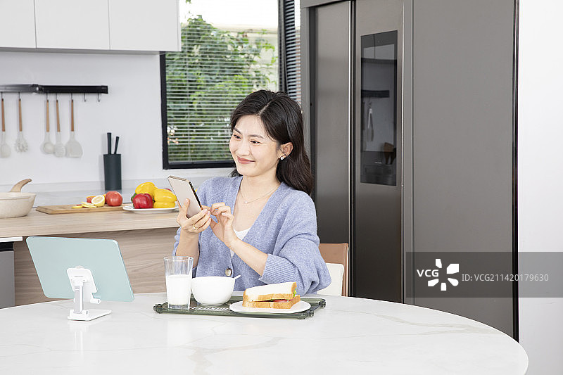 居家吃早餐的年轻女性图片素材