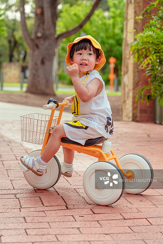 风景区红砖建筑处骑三轮童车男孩图片素材