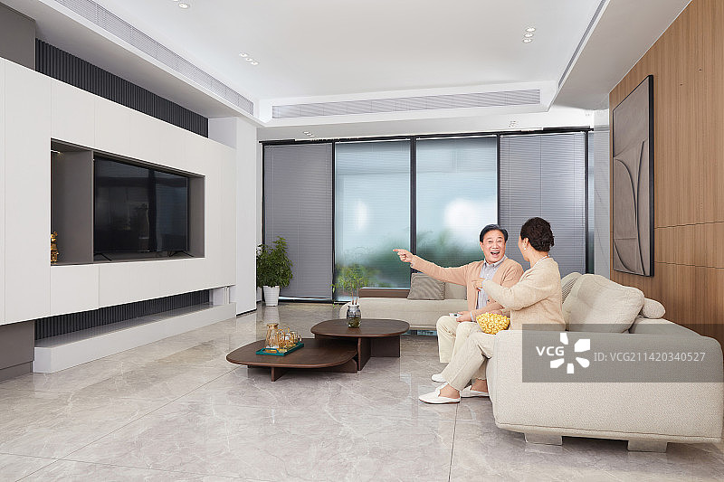 一起在客厅看电视的老年夫妻图片素材