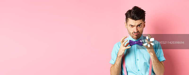 戴着领结，举起双手，要勒死某人的愤怒男子照片图片素材