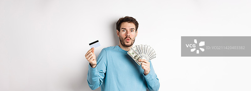 惊讶的年轻人展示美元和信用卡图片素材