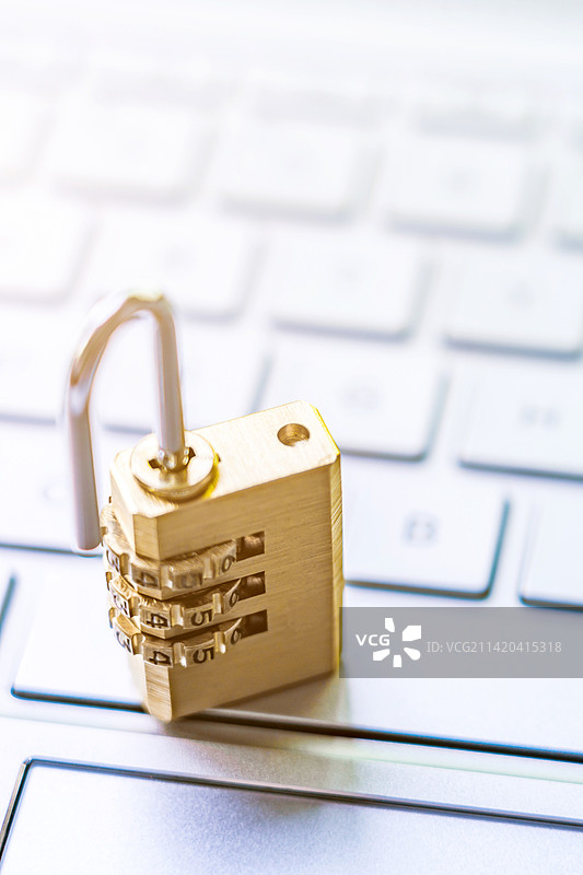一把打开的锁子放在电脑键盘上图片素材