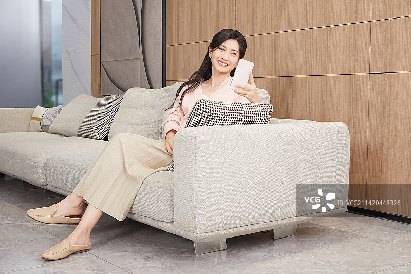 坐在客厅沙发上的年轻女人图片素材