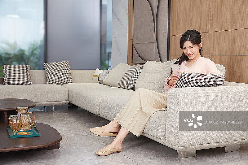 坐在客厅沙发上的年轻女人图片素材