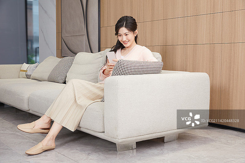 坐在客厅沙发上的年轻女人图片素材