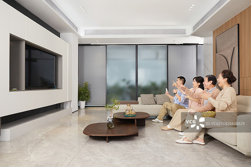 陪伴父母坐在客厅里看电视青年男女图片素材