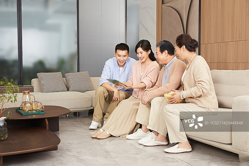 陪伴父母坐在客厅里的青年男女图片素材