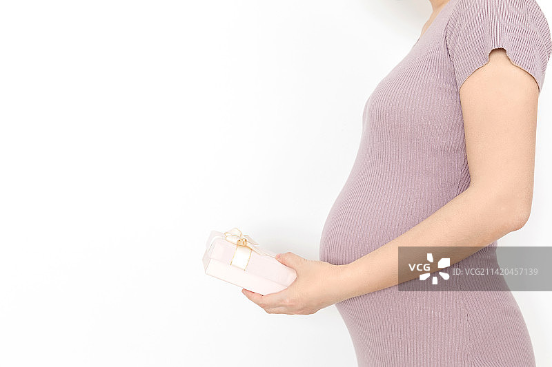 年轻孕妇手拿着一个礼物盒图片素材