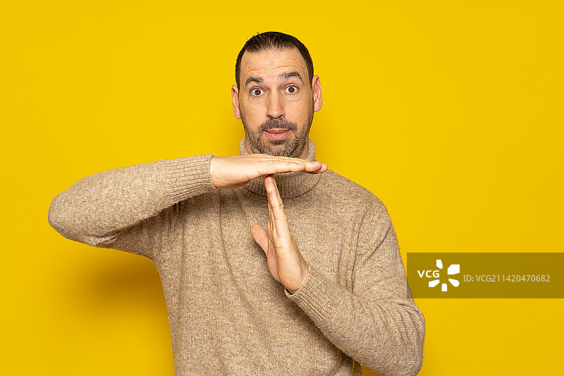 戴高领毛衣的西班牙裔胡须男展示暂停手势图片素材