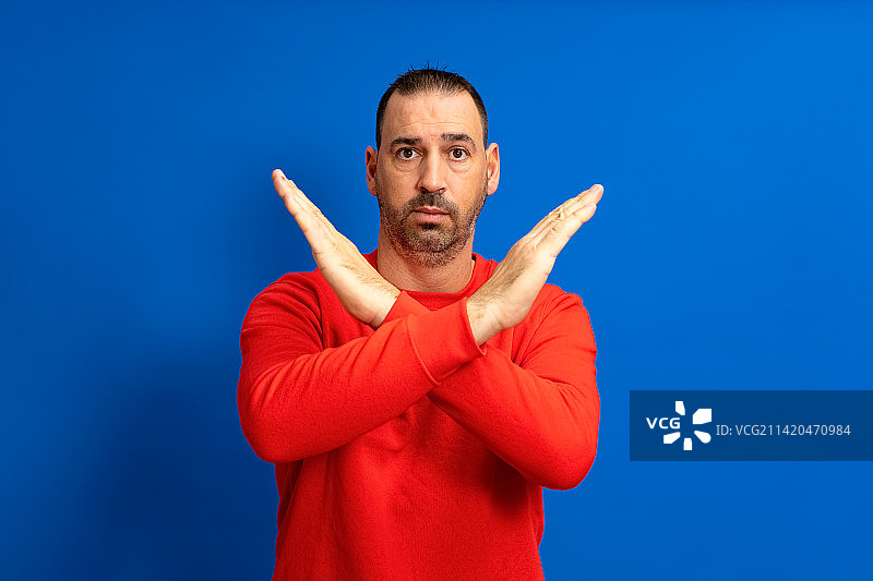 表情严肃的西班牙裔络腮胡男子做出拒绝的手势图片素材