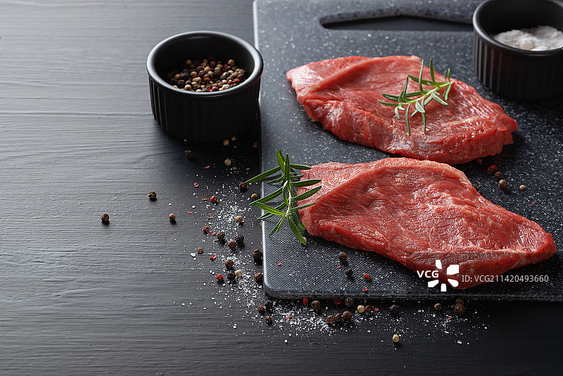 深色砧板上撒有香料的生牛肉牛排图片素材