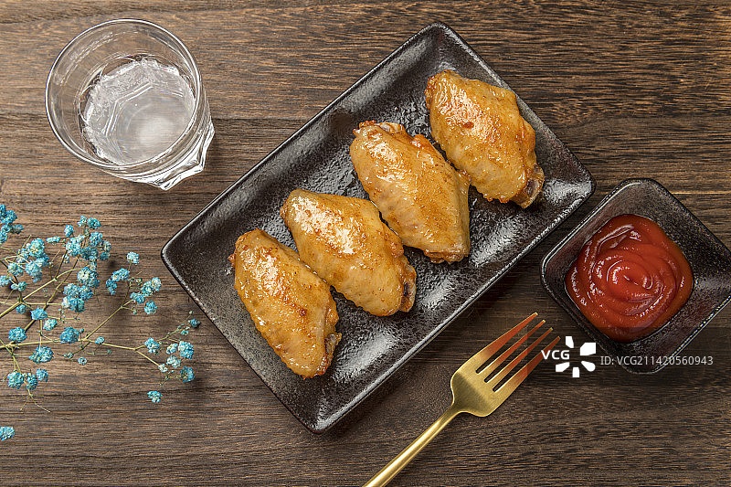 一盘烤鸡翅烤鸡翅中摆放在木桌面上特写图片素材