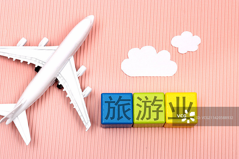 粉色背景下的飞机模型及旅游用品图片素材