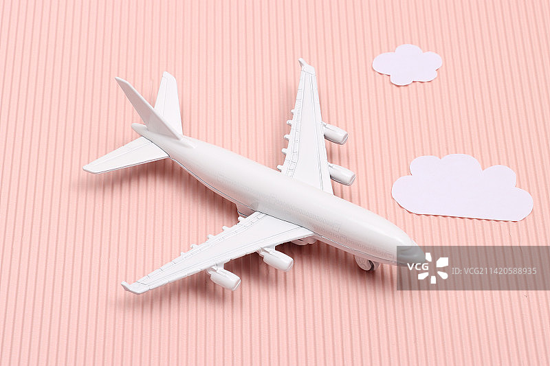 粉色背景下的飞机模型及旅游用品图片素材