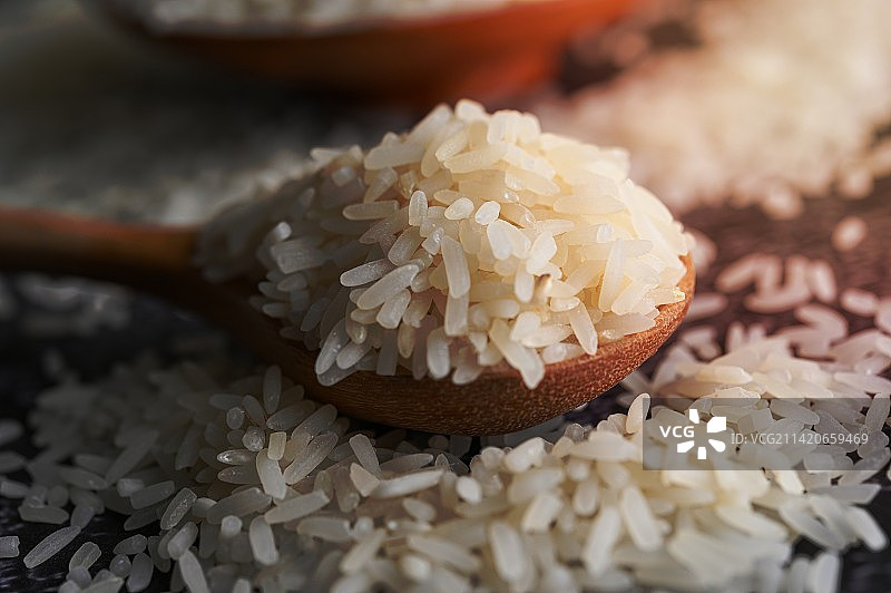 碗里的碾磨米饭和木勺在黑色水泥地上，罗马尼亚图片素材
