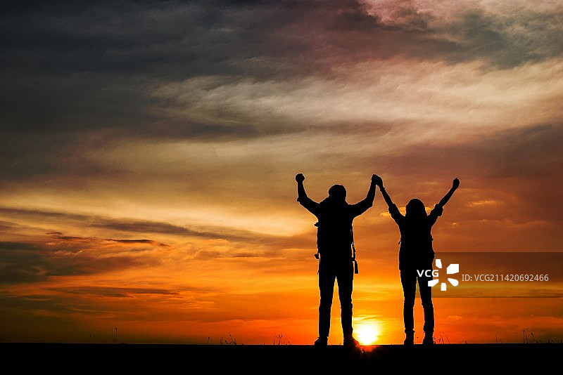 两个背包徒步旅行者欣赏日落的剪影，罗马尼亚旅行概念图片素材