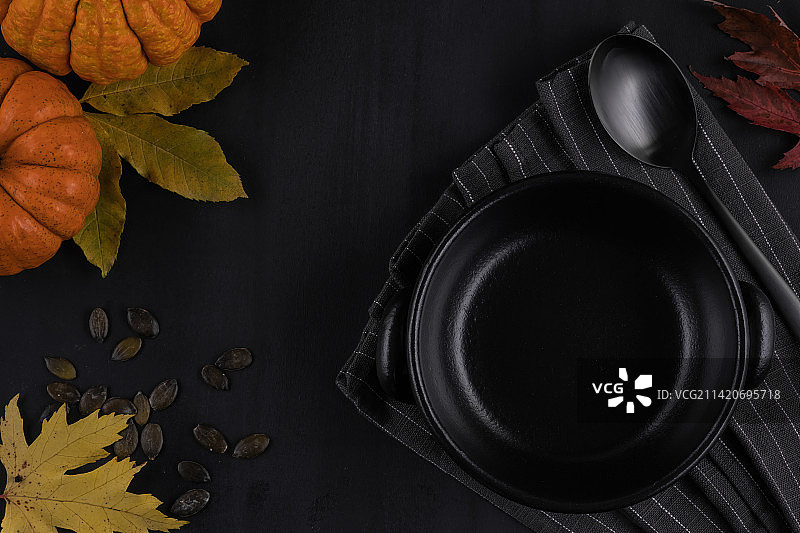 秋季风格的深色背景上的深色盘子和餐巾图片素材