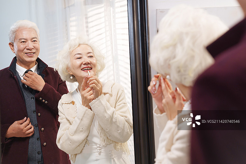 时尚的老年夫妇对着镜子穿衣打扮图片素材
