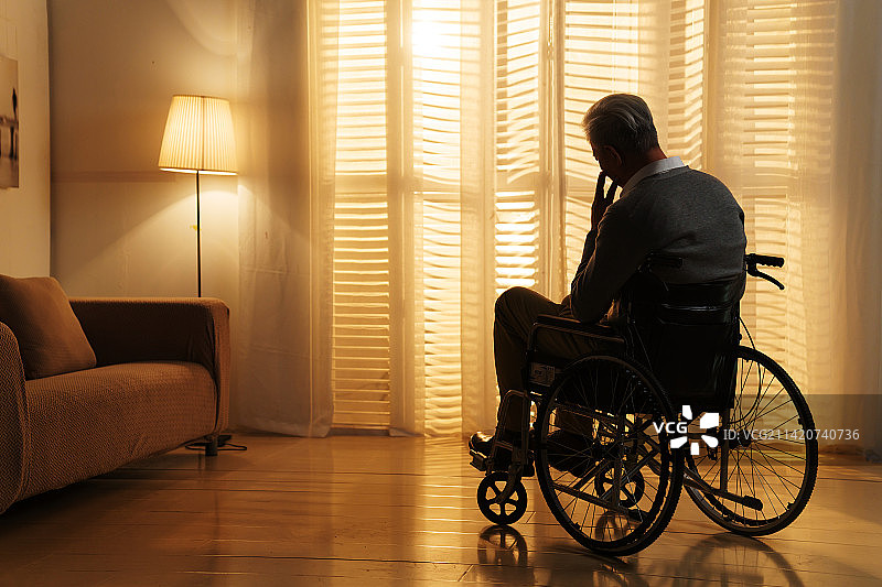 窗前孤独的老年人坐在轮椅上图片素材