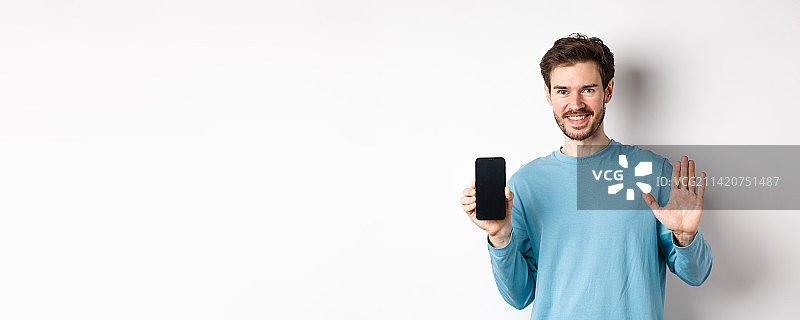英俊的白人男子展示空白智能手机屏幕图片素材