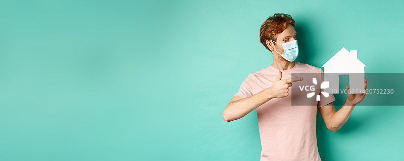 新冠疫情与房地产概念，戴口罩的红发男士图片素材