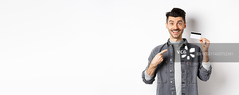 兴奋的英俊男子指着信用卡图片素材