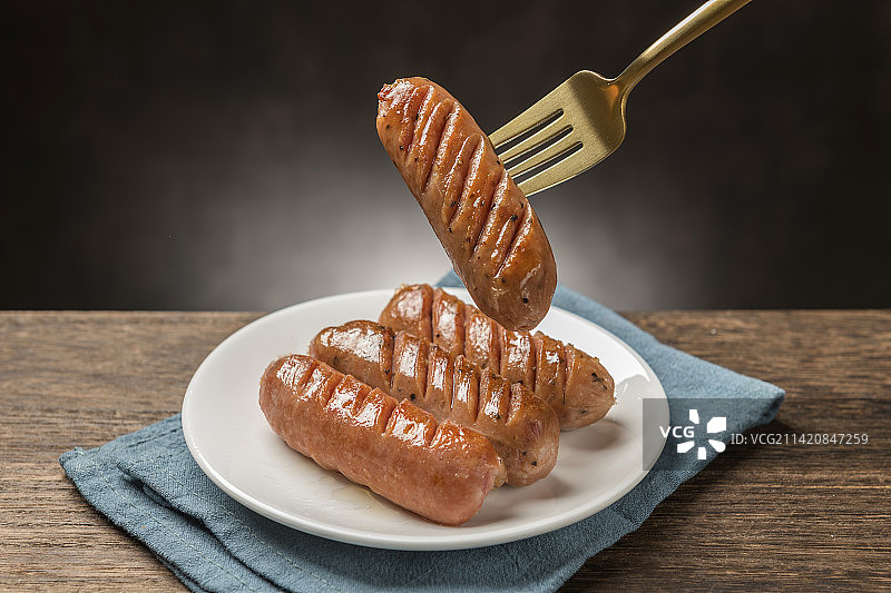 一盘香肠摆放在木桌面上特写图片素材