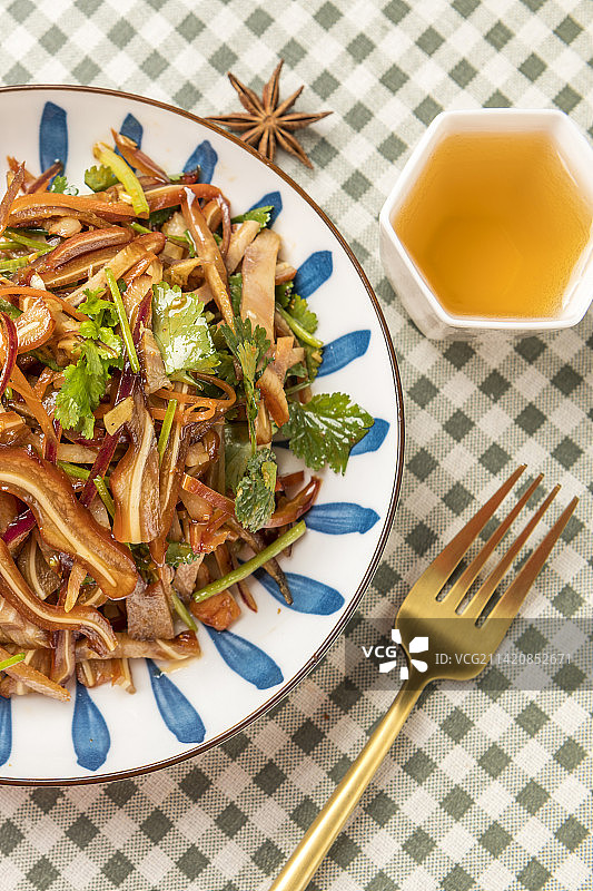 一盘凉拌猪耳朵摆放在格子桌布上特写图片素材