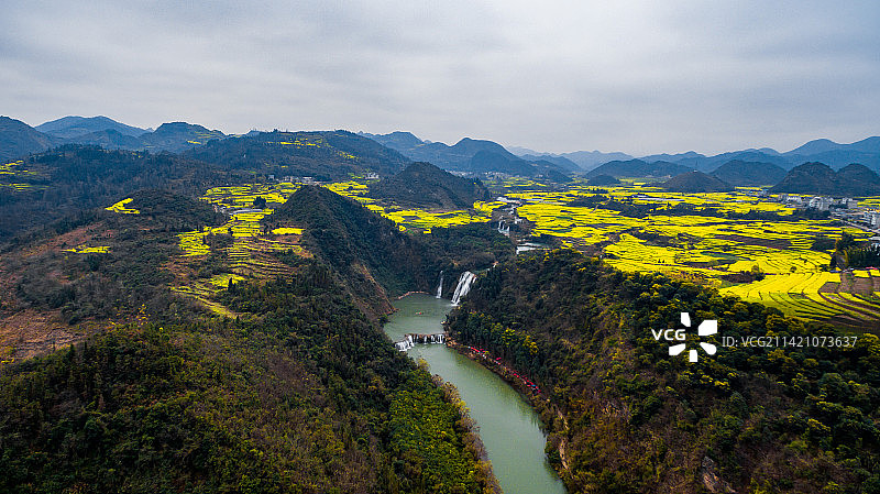航拍春季盛开的云南曲靖罗平九龙瀑布群与油菜花海图片素材