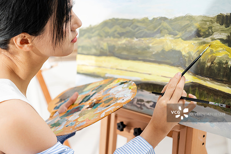 美丽的中国女艺术家在绘画图片素材
