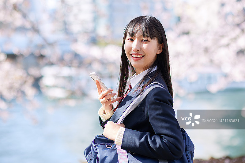 盛开樱花下的日本高中生肖像图片素材