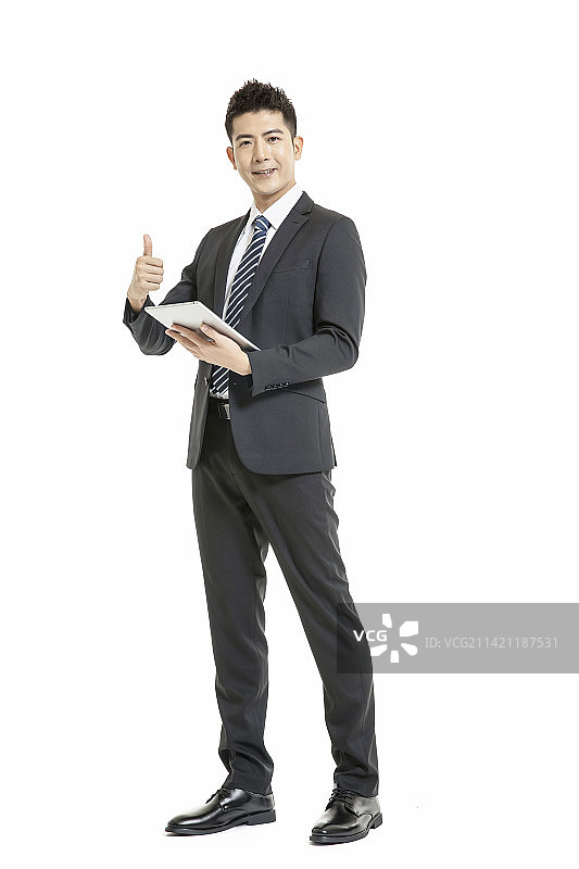 身着深色西装套装手拿平板电脑的年轻男士图片素材
