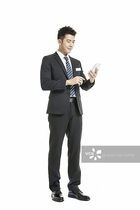 身着深色西装套装使用手机的年轻男士图片素材