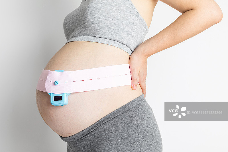年轻孕妇在家里做远程胎心监测图片素材