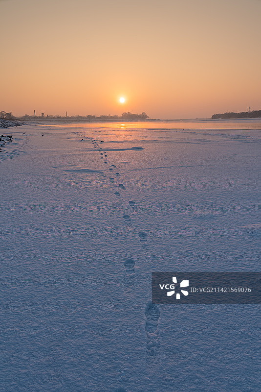 日落时分雪地上的脚印图片素材
