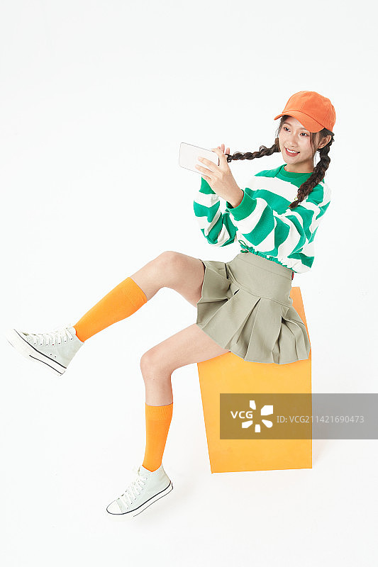 坐在木箱上的年轻女学生图片素材