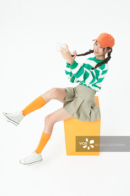 坐在木箱上的年轻女学生图片素材