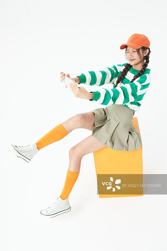 坐在木箱上的年轻女学生图片素材