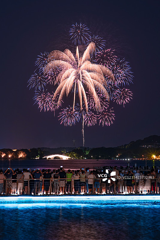 江苏无锡蠡湖之光，中秋节夜晚人们在栈桥上观赏鼋头渚烟花秀。图片素材